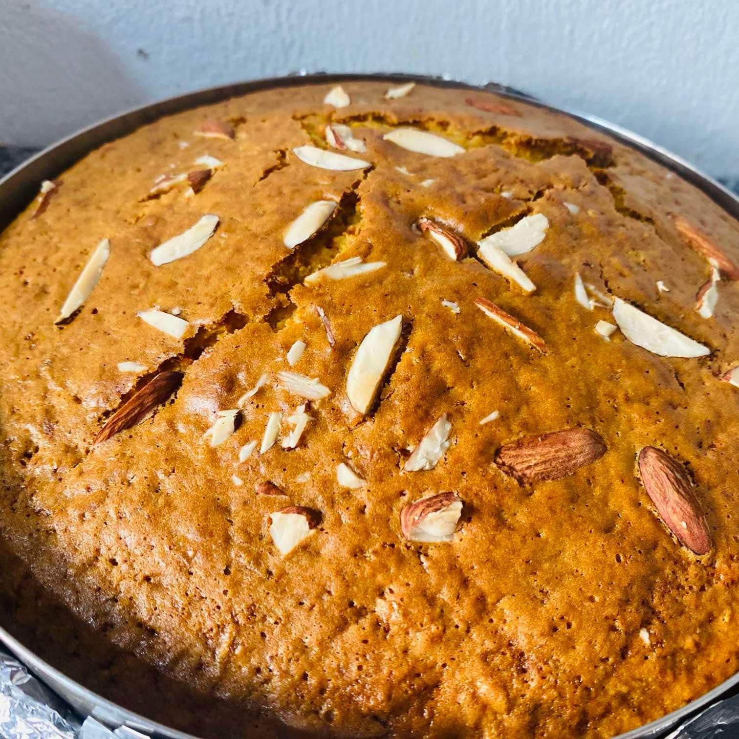 cake sliced into multiple pieces with nuts scattered on top